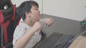 happy winning expression asian little boy kid using computer typing on keyboard