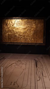 Vertical screen: A golden relief depicting the sacred Apis bull, a symbol of strength and divinity in ancient Egypt. Hieroglyphs and figures illustrate a solemn ceremonial procession.