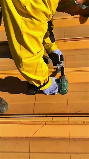 installing solar panel mounting brackets on a corrugated metal roof using a cordless power drill