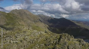 A man hiking a spectacular mountain ridge in the Welsh mountains