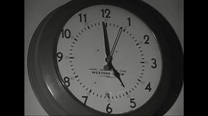 United States CIRCA 1940s: A clock displaying Naval Observatory time is shown in the film clip. The clock face is white, and the hands are black.