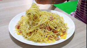 Homemade recipe classic aglio e olio spaghetti with smoked beef and grated corn, close-up in a white plate on the table