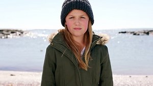 Face, smile and girl at beach on vacation, holiday or trip alone. Freedom, travel and happy child from Canada standing on seashore or ocean coast smiling, enjoying quality time outdoors or having fun