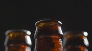 Free stock video - Close up of condensation droplets on neck of bottles of cold beer or soft drinks with water vapour after opening