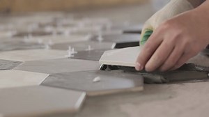 Installing ceramic floor tiles - measuring and cutting the pieces. Construction, renovation, repair apartment. Cuts tile. Tile cutting