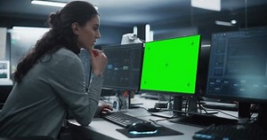 Female Software Developer Working on a Desktop Computer with Green Screen Mock Up Display. Specialist Typing on Keyboard, Coding and Implementing a New Technical Feature, Working in an Agency