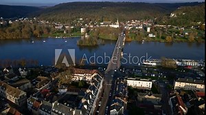 Vernon village with barge on Seine river, Pont Clemenceau bridge, old mill, Tourelles Castle, Saint Nicolas De Vernonnet church in background, Normandy in France. Aerial drone orbiting sideways