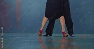 Close-up, a man and a woman are dancing tango, the dancers' legs make beautiful poses and movements. Passionate and beautiful dance in a dark room with smoke. 4k, ProRes