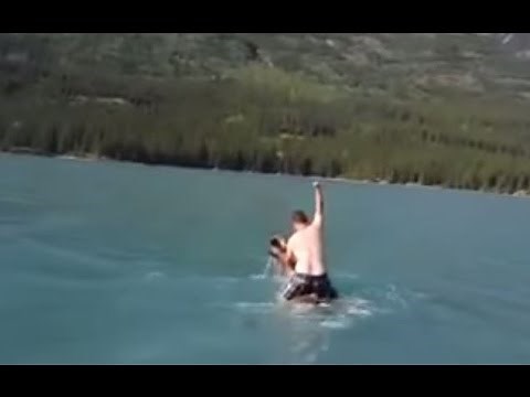 Canadian man rides moose at lake in British Columbia