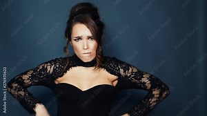 Woman in black dress standing putting hands on belt. Girl expressing indignant