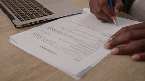 Black Hand Filling Paper Document. Man signing agreement, close up.