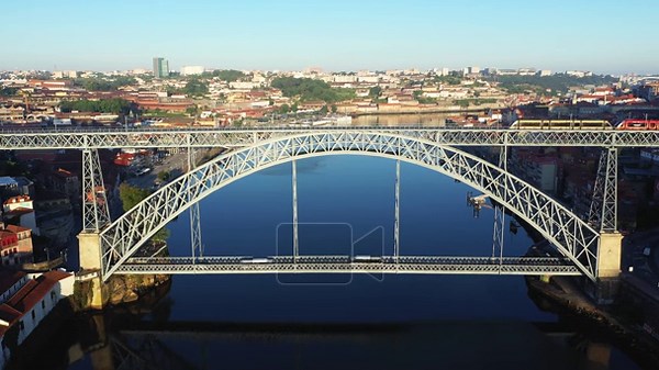 Aerial view of the iconic Dom Luis I Bridge spanning the Douro River in Porto, Portugal, with the cityscape in the background on a clear day Stock Video Footage - Alamy