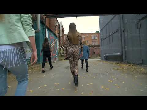 Rear view of girls in trendy, fashionable clothes walking on the street back view. Girls friends