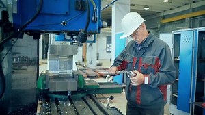 Mechanical technician measuring cutting tool before cnc milling machine center at tool workshop