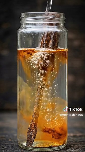 A heavily rusted flat head screwdriver is restored inside a transparent glass jar. The blade, shaft, and handle are covered in thick rust, deep corrosion, and years of oxidation buildup. Using a step-by-step cleaning process with liquid solution, chemical reaction, and fine cleaning powder, the rust gradually breaks down and separates from the metal. The macro view captures bubbling along the blade edge and shaft, followed by rust particles settling into a dense sediment layer at the bottom. By 