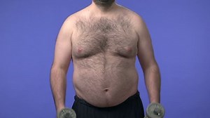 Hairy overweight man lifting weights. High definition video shot on studio blue screen.