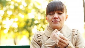 clip-1583935-sick-woman-blowing-her-nose-into-tissue