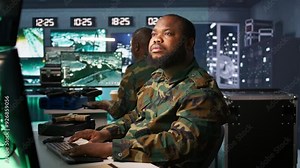 Officer doing tasks in military base, planning, analyzing and gathering information on enemy troops. Agent in base of operations doing assessment of enemy vulnerabilities, tracking, camera B