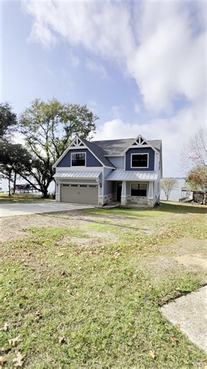 This charming coastal-inspired custom home in Forest Hills on Lake Livingston is now complete, occupying a stunning lakefront homesite surrounded by mature trees. Breathtaking water views await right from the porch! The owners dreamed up this light, airy two-story beauty, with its classic white-and-blue tones, wraparound porches, and open design that perfectly frames the lake. They found our VR technology in the Plan. See. Build. process made all the difference. It let them walk through the visi
