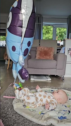 Baby is mesmerized by helium balloon tied to his foot!