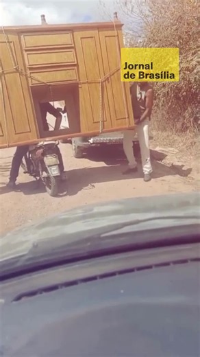 🚚 Durante uma mudança em Cariré, no Ceará, uma caminhonete tentou subir uma ladeira carregando um guarda-roupa de madeira, mas não conseguiu concluir o trajeto. Diante da situação, Antonio Cabeludo encontrou uma solução inusitada para seguir com o transporte do móvel. 🏍️ Com a ajuda de outras pessoas para equilibrar o guarda-roupa, o móvel foi colocado sobre uma Honda Biz e levado pela estrada de terra. A cena chamou atenção pela criatividade, mas também pelo risco da manobra. 📱 O vídeo reper
