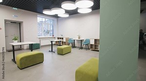 Modern classrooms with comfortable chairs ottomans and desks. Study rooms in converted school classrooms with cold ceiling lights