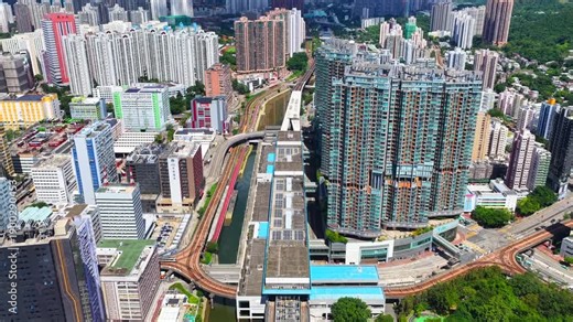 Aerial skyview of Tuen Mun subway extension project in Hong Kong, featuring elevated railway construction along Tuen Mun River and road, new station development and temporary work platforms