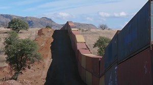 Border barrier of shipping containers snakes across Arizona wilderness