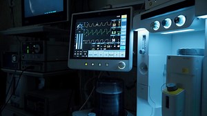 Advanced life support equipment displays patient's vital signs, creating a tense atmosphere in a dimly lit operating room, highlighting the importance of technology in critical care