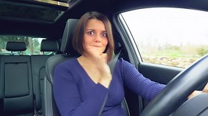Beautiful funny woman dancing in car full of positive energy