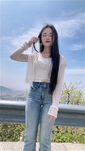 It looks like a woman posing for a short video (similar to a TikTok/Douyin-style post).She’swearing