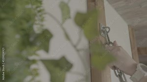 Closeup still of person hooking and attaching chain to wall hook, chaining Stock Video