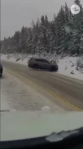 Officer narrowly dodges a car skidding off the road amid a snowstorm