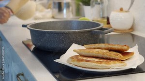 woman cooking homemade pasties frying chebureks in the kitchen at home