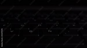 illuminated keyboard buttons letters in RGB colors on modern black laptop
