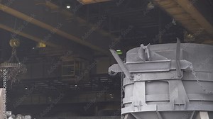 Steelmaking, the process of loading scrap metal into a tank for steel melting, gantry cranes with magnets at work, heavy industry.