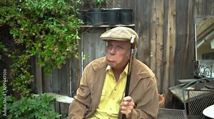 Hysterical and deranged old man holding cane in a threatening manner and making crazy faces, including pouting.