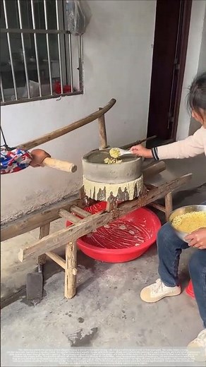 Traditional stone mill grinding for making soy milk.
