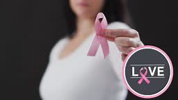 Love text banner with pink ribbon icon against mid section of woman...