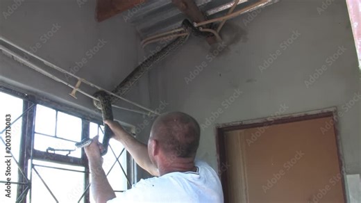 men carefully handle a massive African rock python From house Indoor Ceiling in a rural Botswana setting