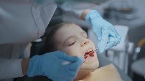 Close up face of girl patient with open mouth during dental checkup prevention toothache. Hands of female dentist examine teeth condition of kid use tools.