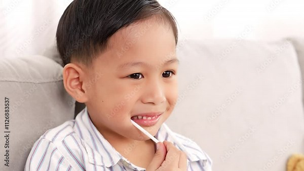 Smile Cute toddler asian little boy eating lollipop or candy It is bad thing of sugar on teeth, Can use for Advertising, dental care concept