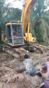 Workers helping tow a bulldozer stuck in a muddy lake | Agricultral Harvers