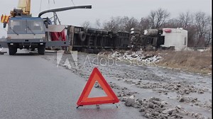 Emergency triangle, Road debris, Car accident. An accident has left a truck smashed up on the side of the road, with an emergency triangle visible in the foreground.