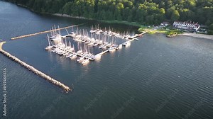 Aerial shot of marina with sailboats, a dock and hotel in a woodland area on the Flensburg Fjord near Wassersleben. Coastal scenery on the Flensburg Fjord with sailing boats moored at a marina.