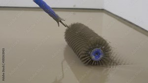 Leveling with a mixture of cement floors.Needle roller for bulk floor.Epoxy Concept. Self-leveling epoxy with needle roller.