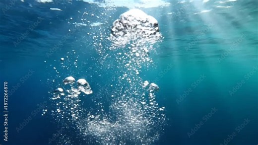 Underwater view of rising bubbles with sunlight streaming through the water reflecting on the surface creating an aquatic scene.