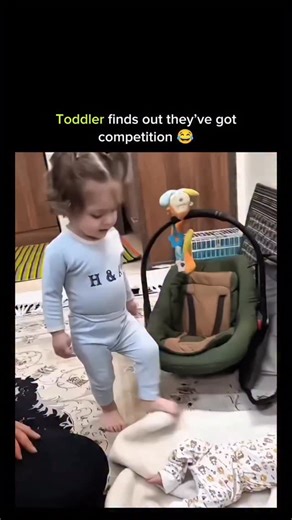 Universal View on Instagram: "This post shows a toddler hitting peak betrayal architecture the instant the new baby coos from the bassinet-eyes widening into full saucer mode, lower lip quivering like it’s been personally offended by physics itself, then launching into a slow-motion march toward parental betrayal with arms crossed so tightly it looks like self-imposed handcuffs while muttering something that sounds suspiciously like a tiny manifesto against sharing oxygen. The chaotic toddler en
