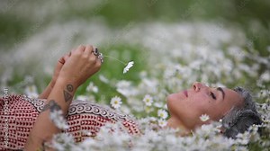 Beautiful women laying on the flowers in the nature.
