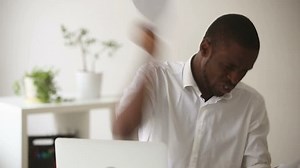 Stressed angry african businessman tired of difficult multitasking job, worried about missing deadline, cannot find lost document, throwing papers on office desk and quits, having bad day at work